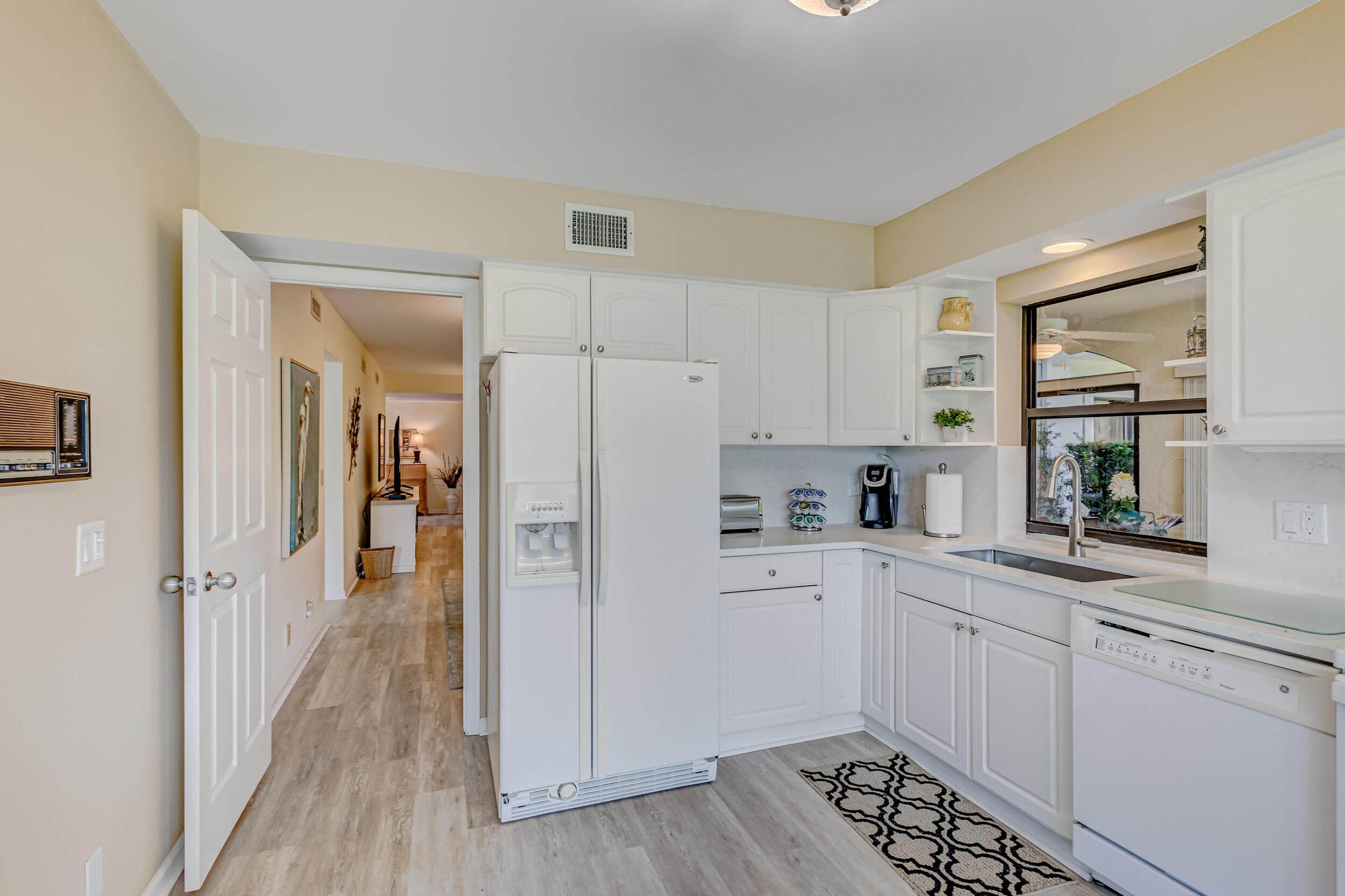 16623 Traders Crossing North, Unit 131 Jupiter, FL 33477 - Photo 16 of 42 a kitchen with white cabinets and appliances