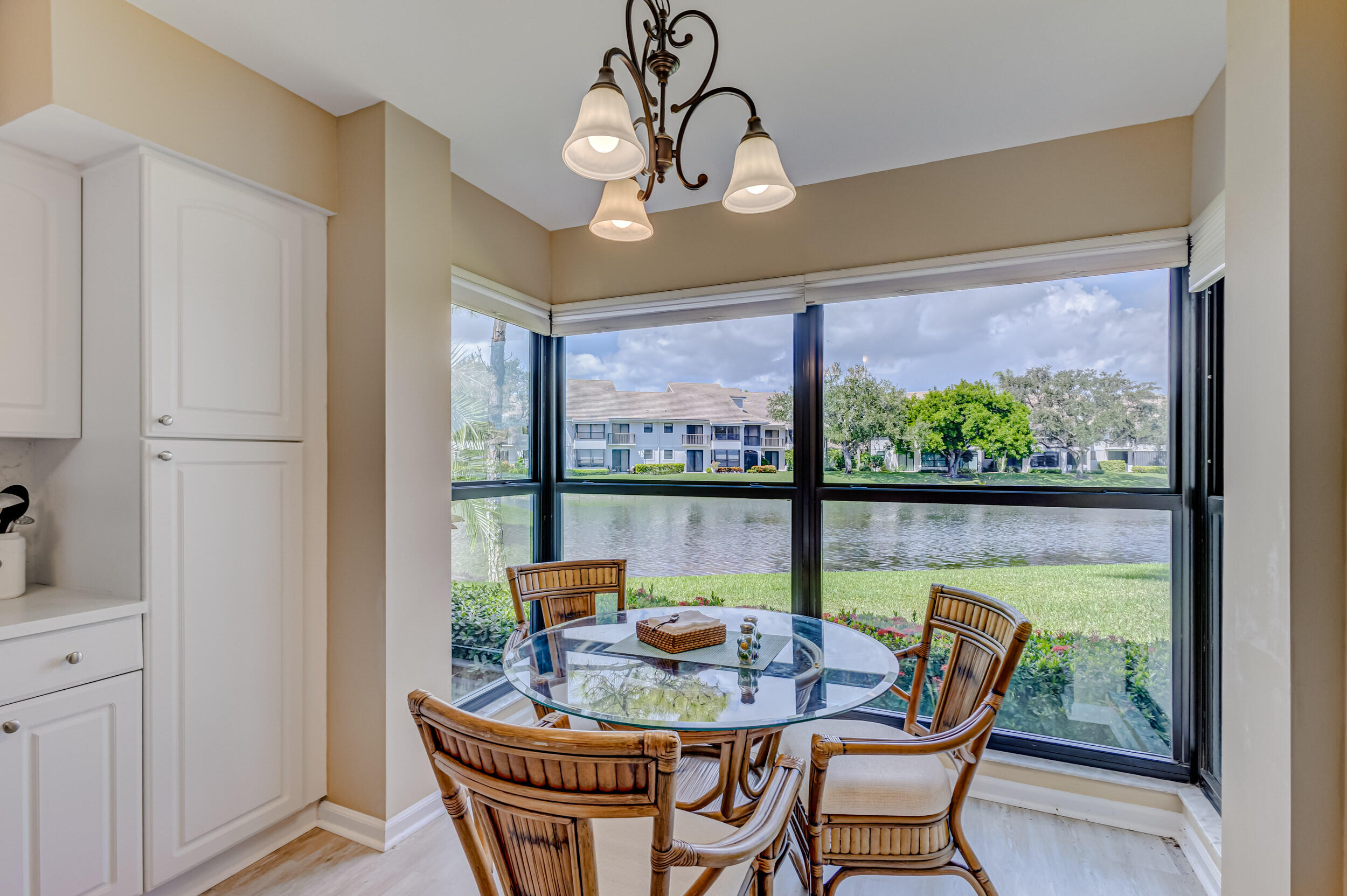 16623 Traders Crossing North, Unit 131 Jupiter, FL 33477 - Photo 17 of 42 a dining room with furniture a chandelier and wooden floor
