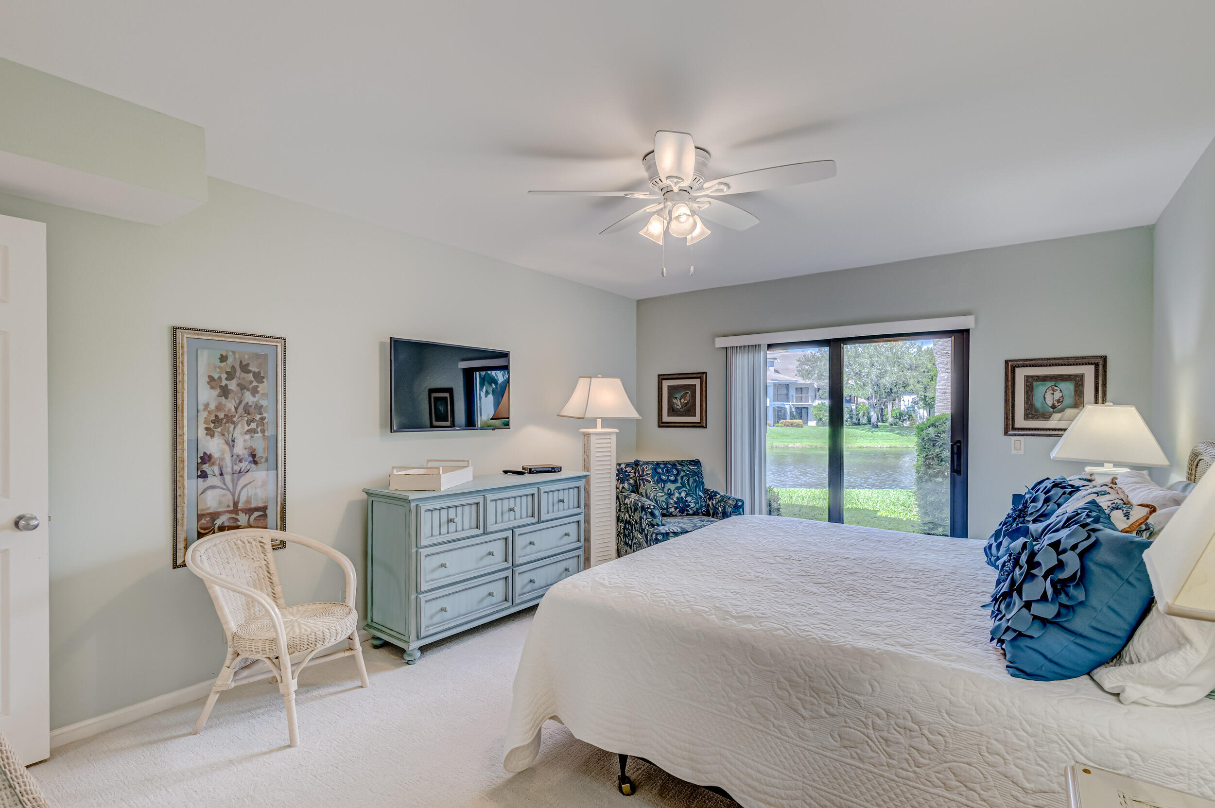 16623 Traders Crossing North, Unit 131 Jupiter, FL 33477 - Photo 25 of 42 a spacious bedroom with a large bed and a chandelier