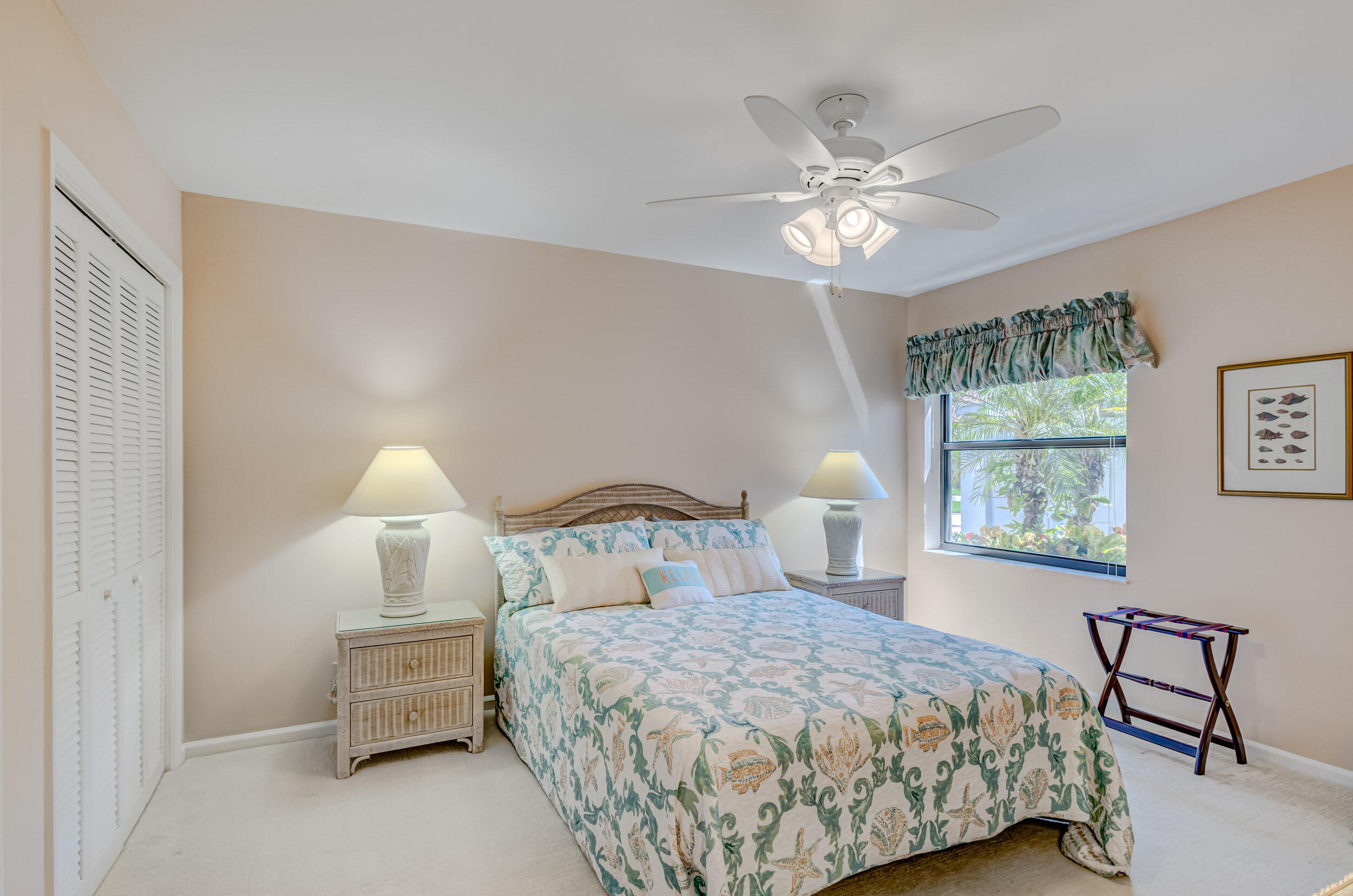 16623 Traders Crossing North, Unit 131 Jupiter, FL 33477 - Photo 29 of 42 a bedroom with a bed and a chandelier