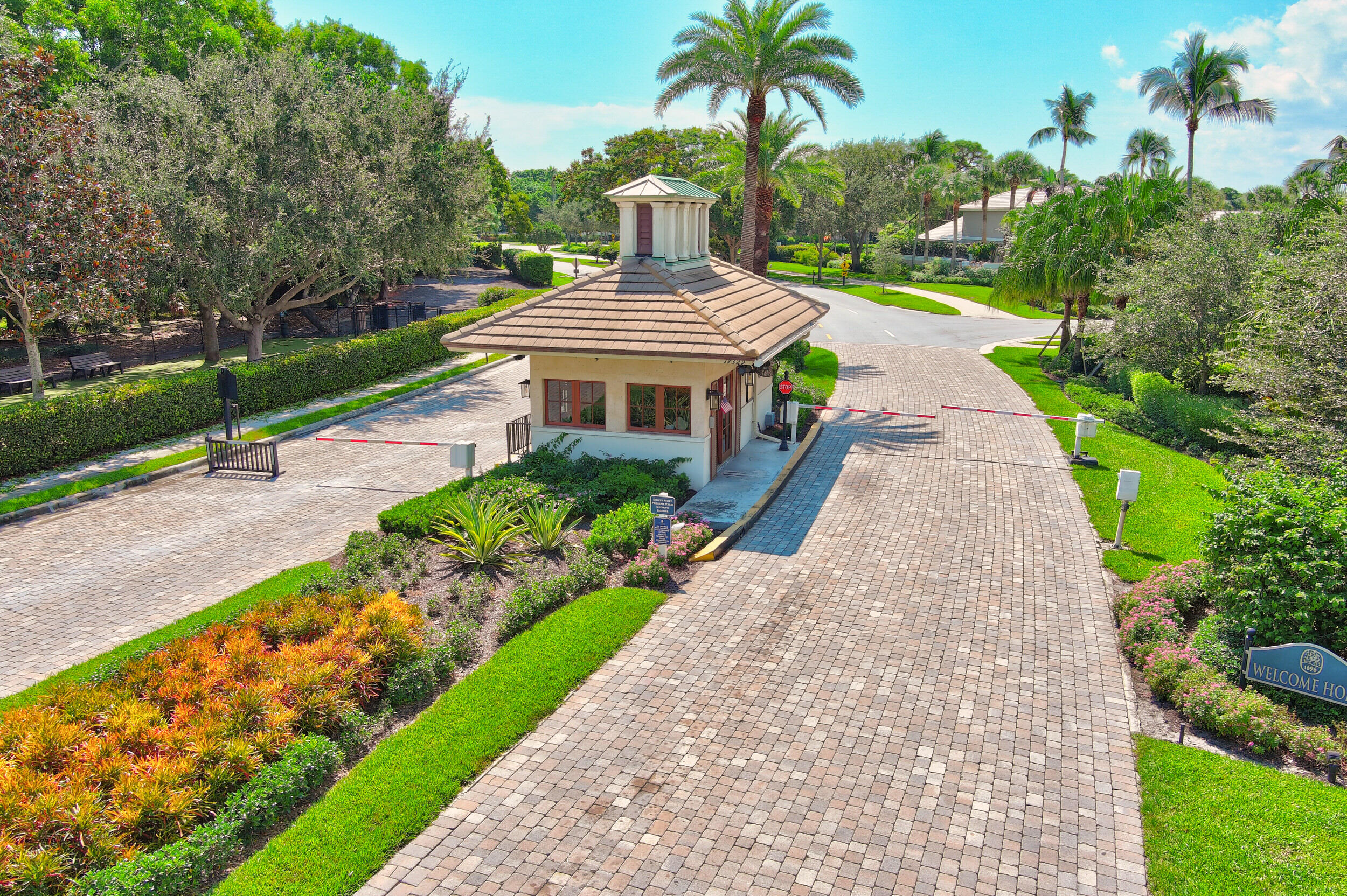 16623 Traders Crossing North, Unit 131 Jupiter, FL 33477 - Photo 42 of 42 a front view of a house with a yard and potted plants