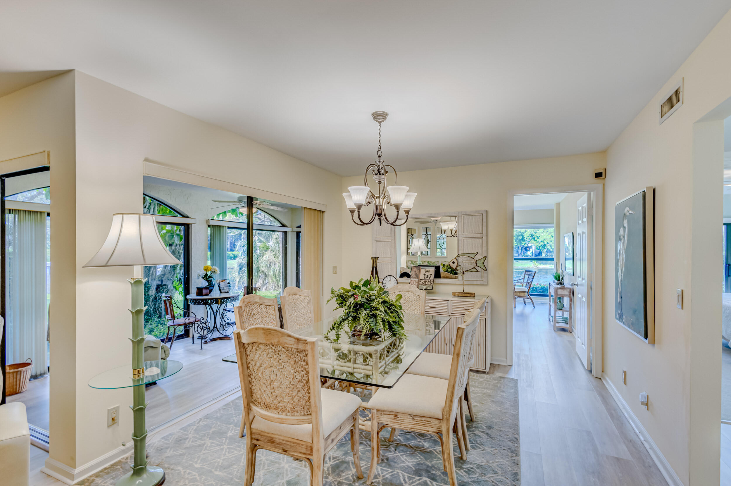 16623 Traders Crossing North, Unit 131 Jupiter, FL 33477 - Photo 9 of 42 a dining room with furniture a chandelier and wooden floor