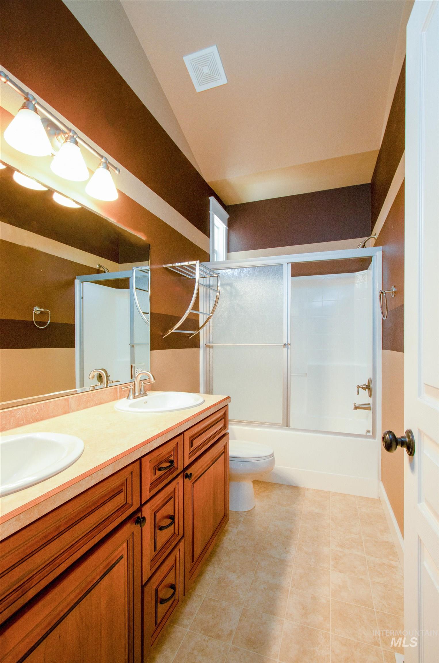 892 South Capitola Way Boise, ID 83712 - Photo 9 of 34 Bathroom featuring a wood-finish double vanity with dual sinks, a neutral-toned countertop, and a track light fixture