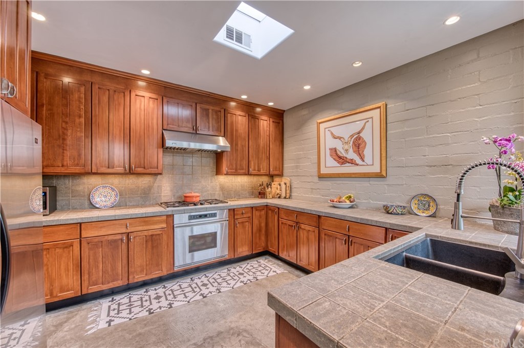 600 Chaparral Road Sierra Madre, CA 91024 - Photo 9 of 25 a kitchen with stainless steel appliances granite countertop wooden cabinets a sink and dishwasher