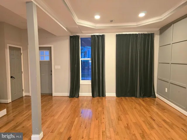 a large living room with stainless steel appliances wooden floors