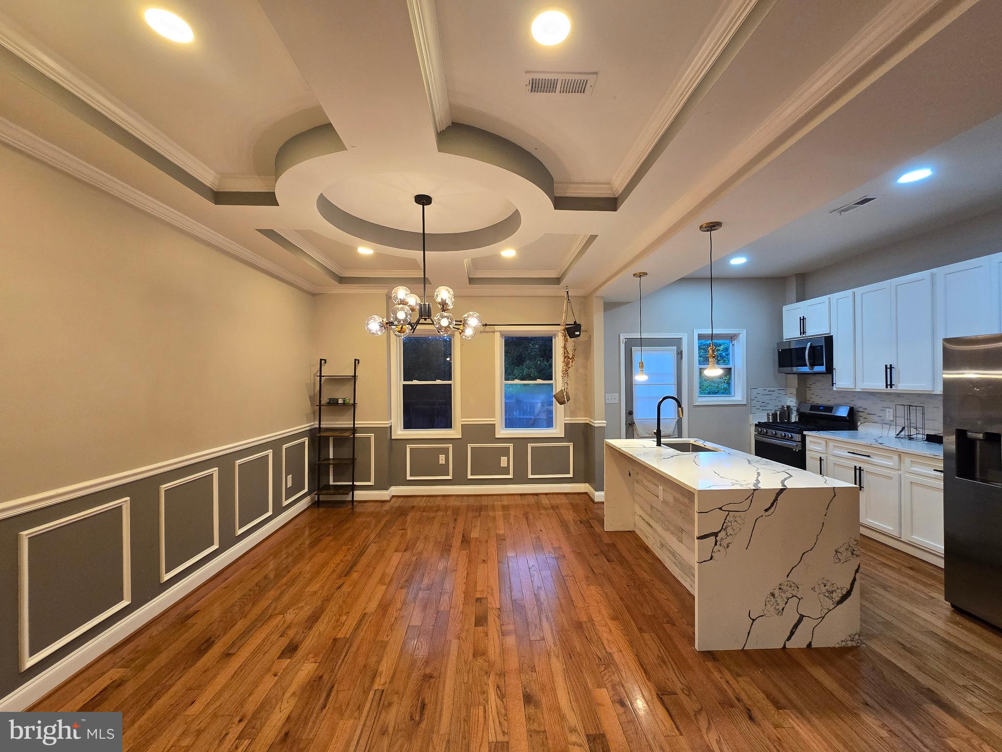 3105 Chelsea Terrace Baltimore, MD 21216 - Photo 12 of 58 a large living room with stainless steel appliances wooden floors