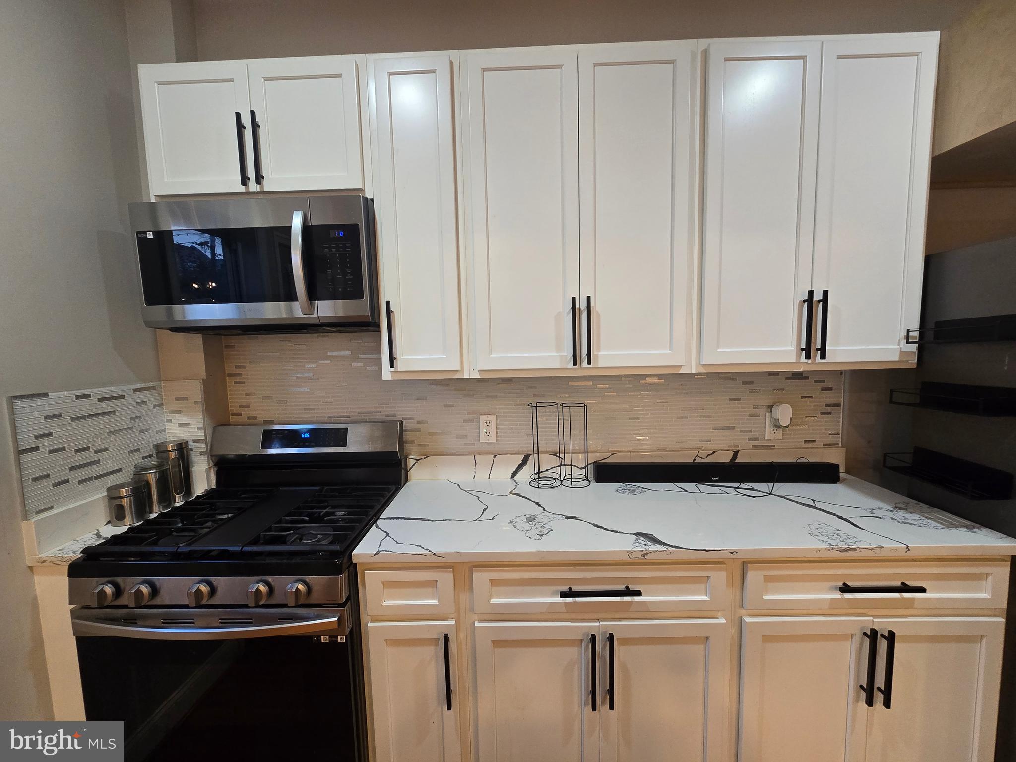 3105 Chelsea Terrace Baltimore, MD 21216 - Photo 21 of 58 a kitchen with granite countertop a stove a sink and a microwave