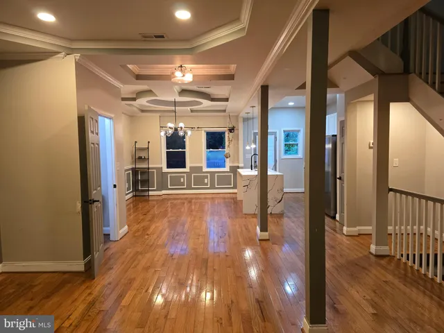 a view of a hallway with wooden floor and chandelier