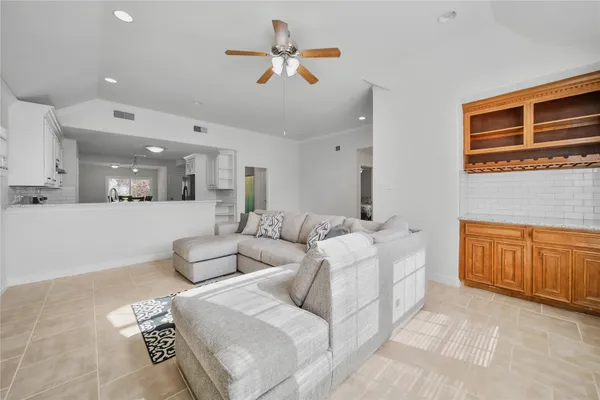 a living room with furniture and a ceiling fan