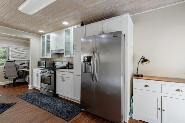 a kitchen with stainless steel appliances granite countertop a refrigerator and a sink
