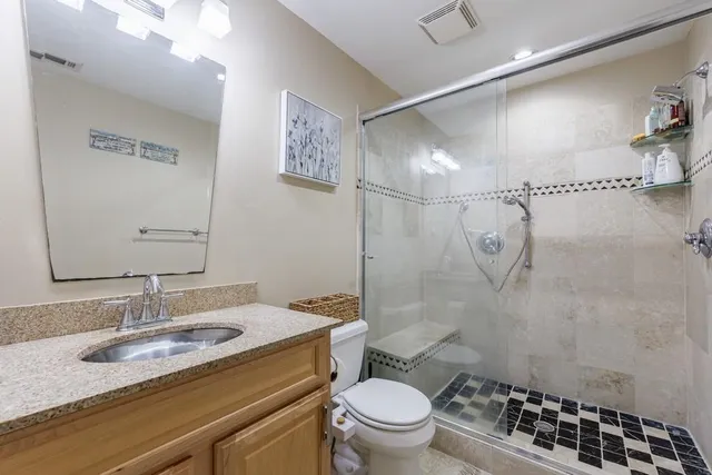 an aerial view of a house with outdoor space and trees all around