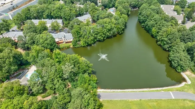 an aerial view of residential house with outdoor space and trees all around