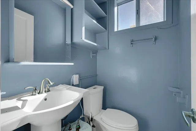 a white toilet sitting next to a bathroom sink
