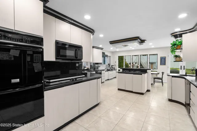 a large white kitchen with stainless steel appliances