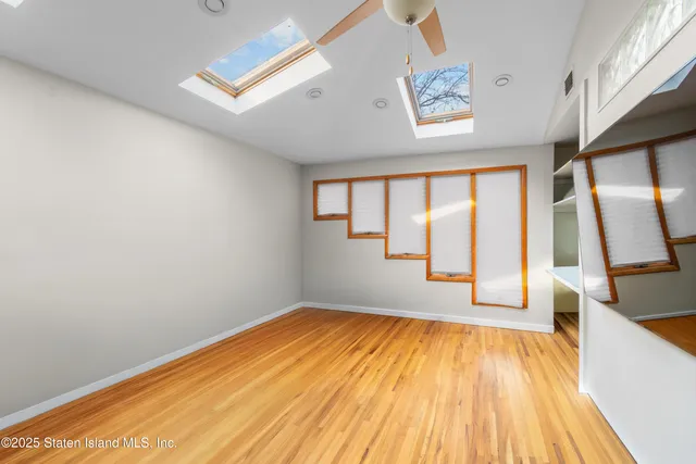 a view of empty room with a window and wooden floor