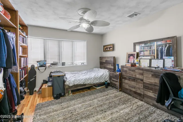 a bedroom with a bed next to a window and a flat screen tv