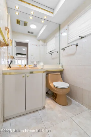 a bathroom with a toilet sink a mirror and shower