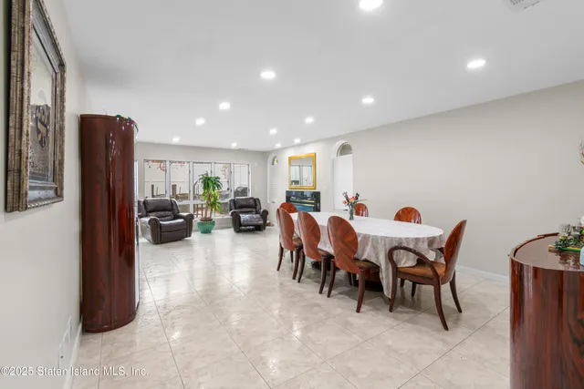 a living room with furniture a dining table and a refrigerator