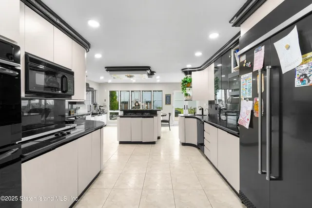 a kitchen with stainless steel appliances kitchen island granite countertop a refrigerator and a stove top oven