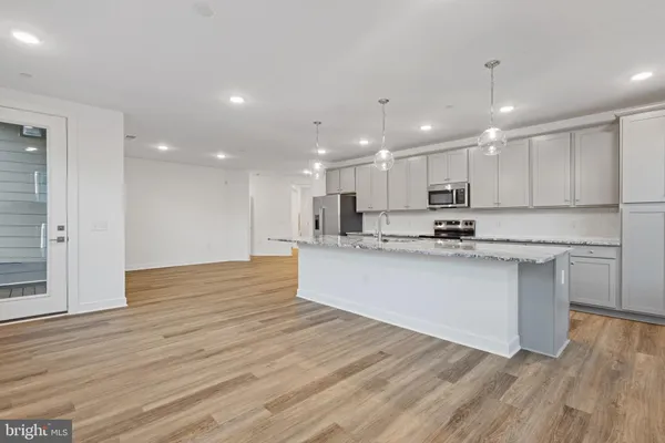 a view of kitchen with granite countertop stainless steel appliances refrigerator sink and cabinets