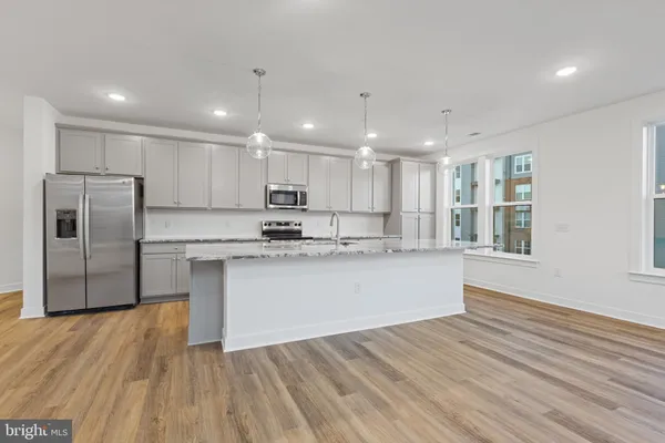 a kitchen with a refrigerator sink and cabinets
