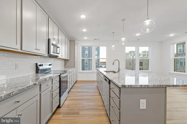 a large kitchen with stainless steel appliances granite countertop a lot of counter space and a sink