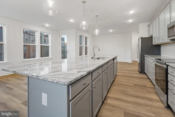 a large kitchen with kitchen island a sink appliances and a counter top space