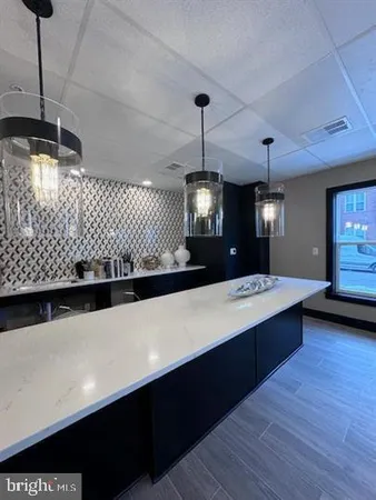 a large kitchen with a sink a counter space and wooden floor