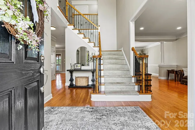 a large kitchen with stainless steel appliances granite countertop a refrigerator a stove and a sink dishwasher with wooden floor