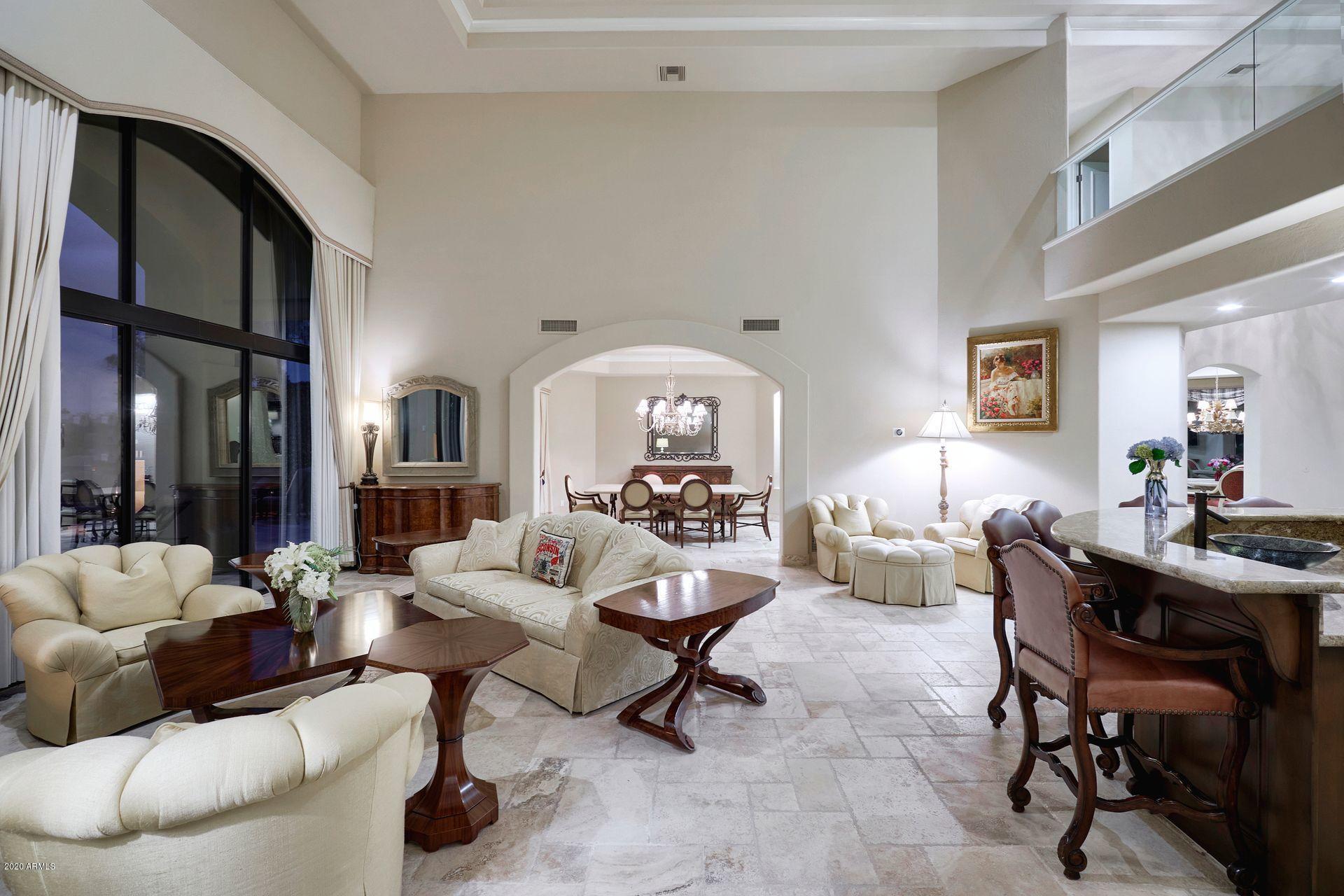 7323 East Gainey Ranch Road, Unit 4 Scottsdale, AZ 85258 - Photo 12 of 56 a living room with furniture a rug and a chandelier