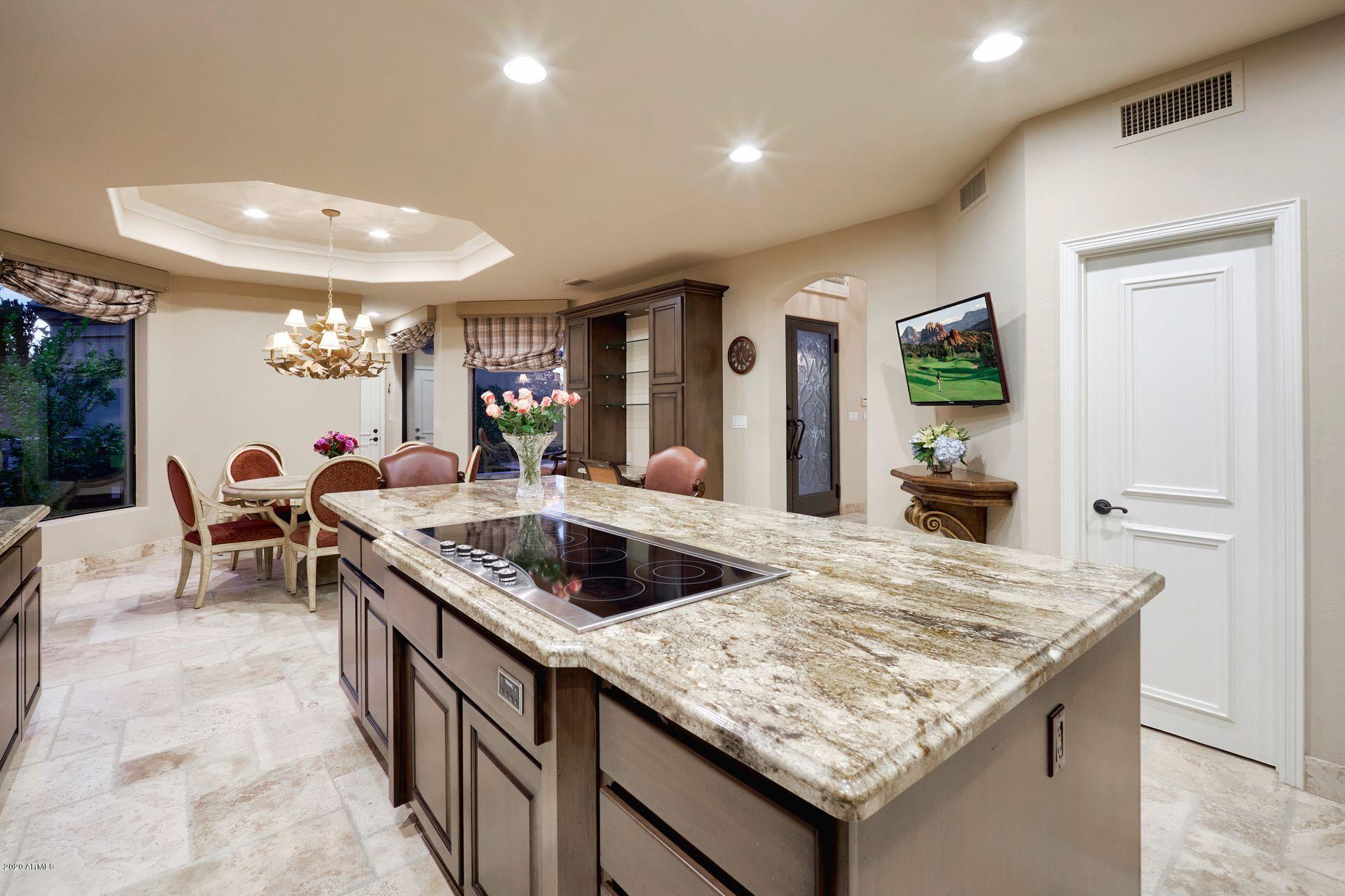 7323 East Gainey Ranch Road, Unit 4 Scottsdale, AZ 85258 - Photo 21 of 56 a kitchen with granite countertop sink and natural light