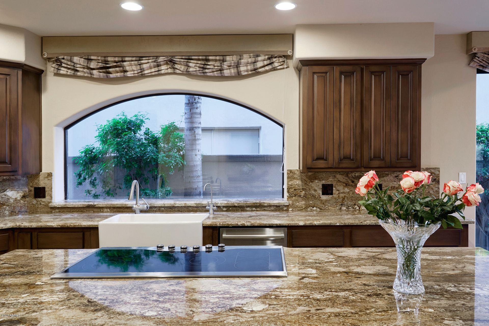 7323 East Gainey Ranch Road, Unit 4 Scottsdale, AZ 85258 - Photo 22 of 56 a kitchen with kitchen island granite countertop a sink and a white cabinets