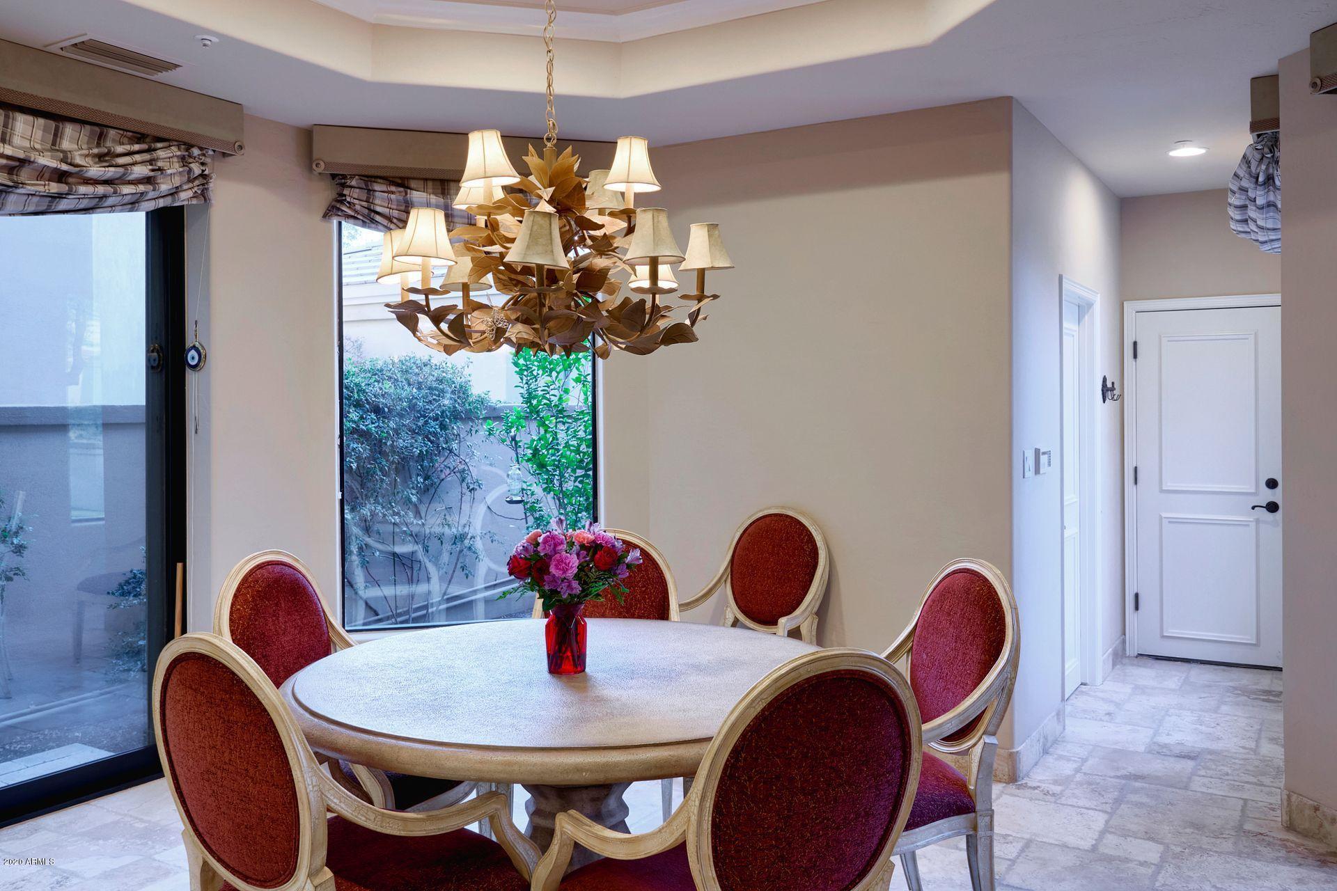 7323 East Gainey Ranch Road, Unit 4 Scottsdale, AZ 85258 - Photo 23 of 56 a dining room with furniture and chandelier