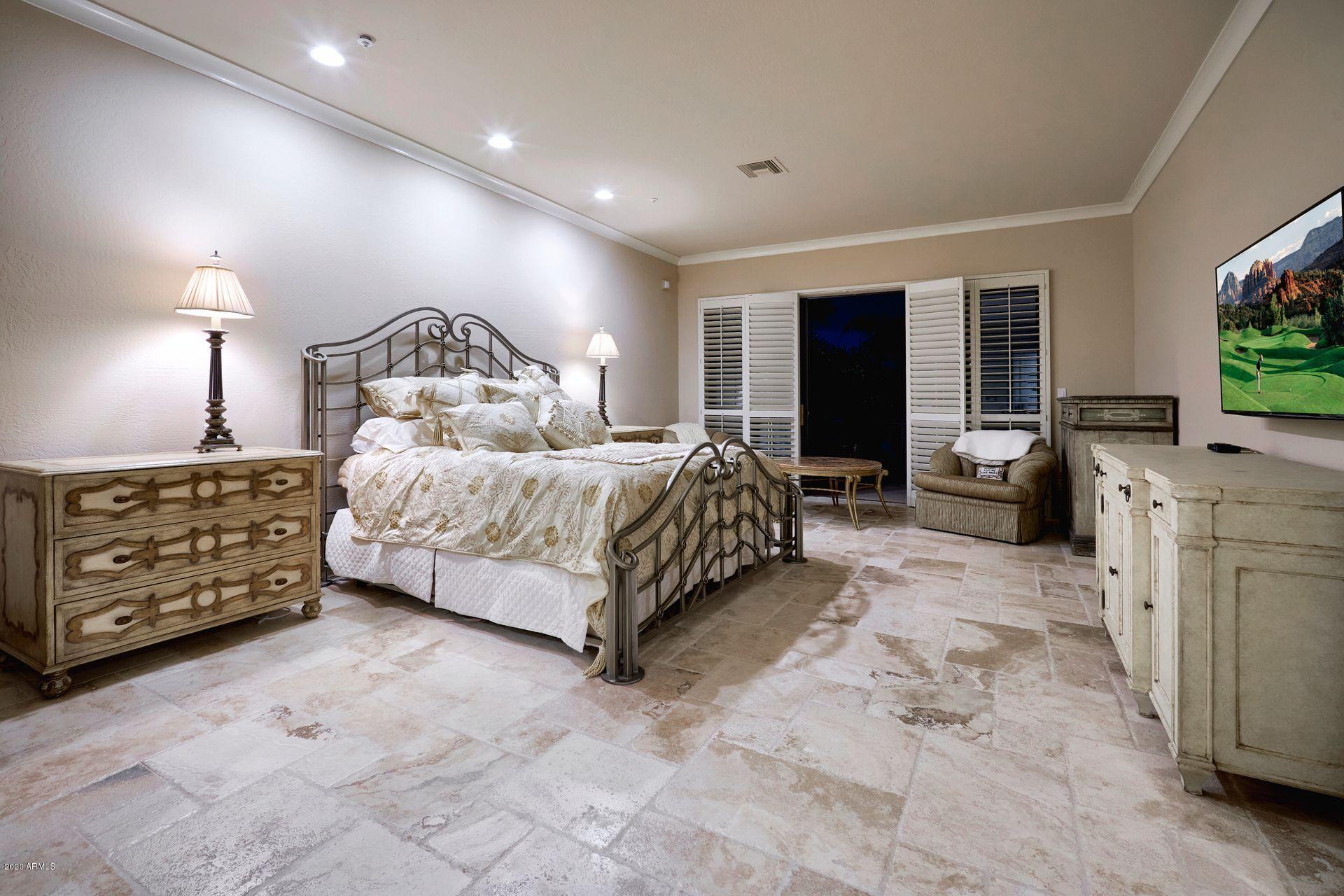 7323 East Gainey Ranch Road, Unit 4 Scottsdale, AZ 85258 - Photo 29 of 56 a bedroom with a bed a couch and a flat screen tv