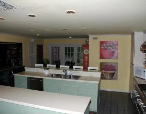 a kitchen with kitchen island a sink appliances and a counter top space
