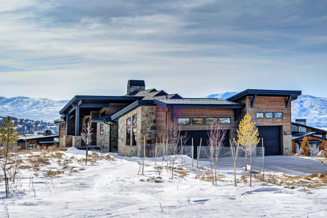 1282 Chimney Rock Road, Unit 344 Heber City, UT 84032 - Photo 50 of 55 Modern mountain-style exterior featuring a stone and wood facade, multiple garage doors, and dark trim