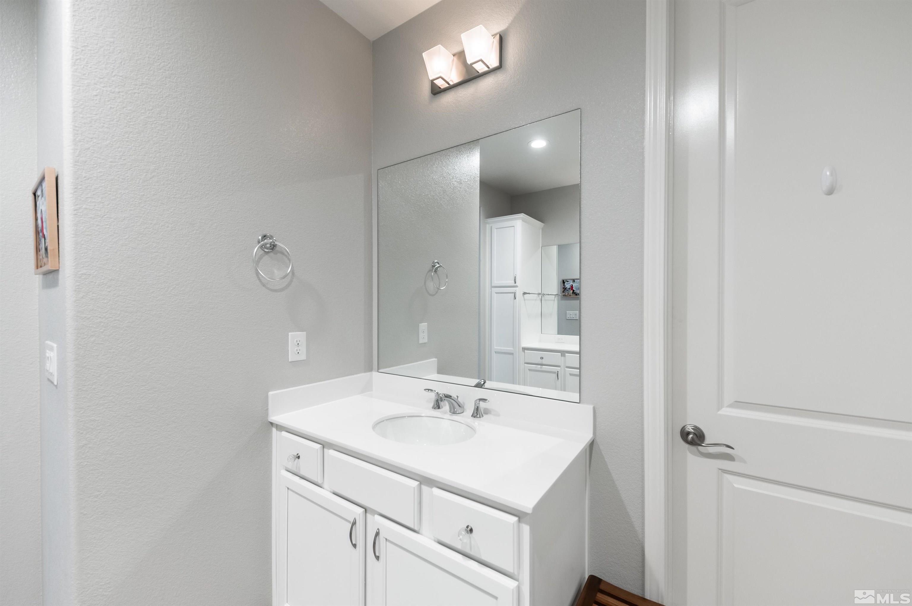9566 Gazala Lane Reno, NV 89521 - Photo 18 of 40 a bathroom with a sink a light fixture and a mirror