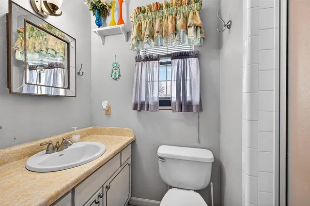 an empty room with chandelier fan and windows