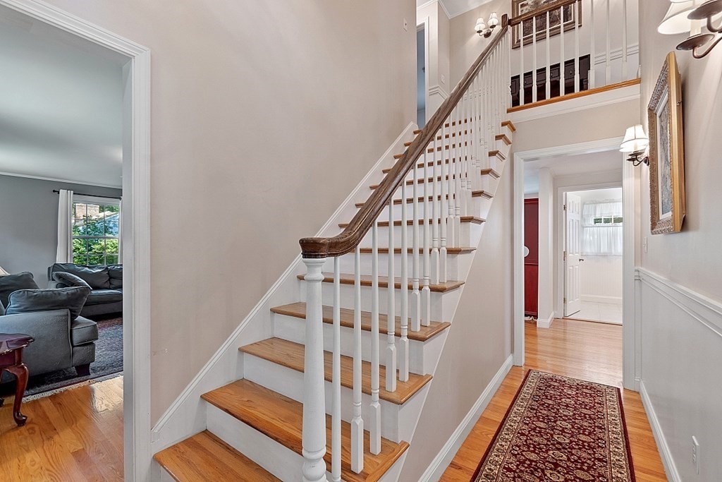 76 Wheeler Road Stow, MA 01775 - Photo 3 of 31 a view of staircase with lots of frames on wall and a rug