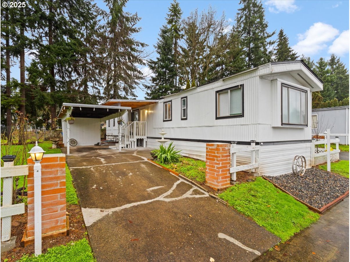 a view of a white house with a yard and furniture