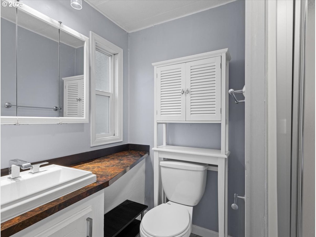 6610 Northwest Whitney Road, Unit 138 Vancouver, WA 98665 - Photo 26 of 34 a bathroom with a granite countertop toilet sink and mirror