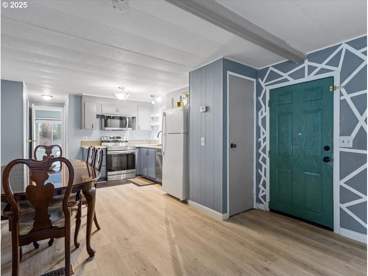 6610 Northwest Whitney Road, Unit 138 Vancouver, WA 98665 - Photo 6 of 34 a kitchen with stainless steel appliances a dining table chairs refrigerator and cabinets