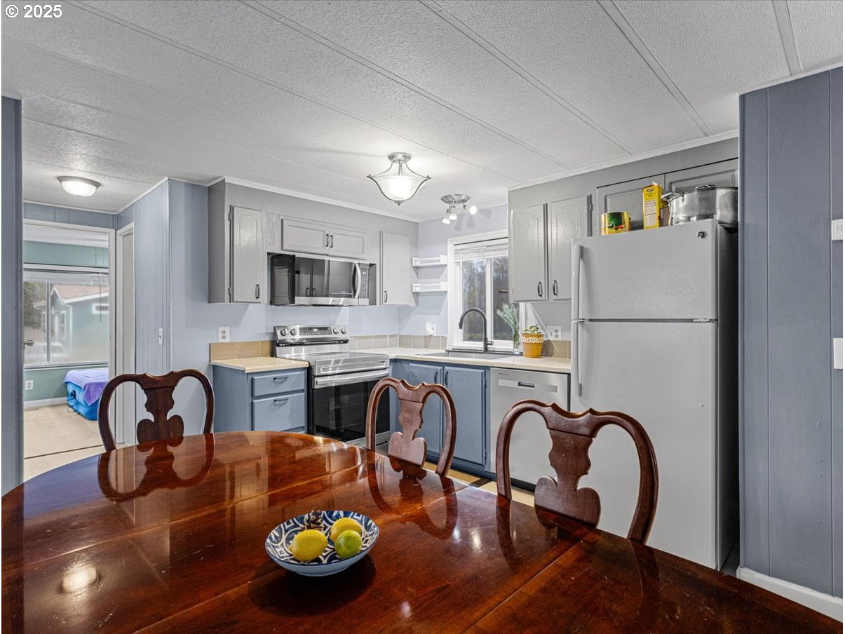 6610 Northwest Whitney Road, Unit 138 Vancouver, WA 98665 - Photo 7 of 34 a kitchen with dining table and stainless steel appliances
