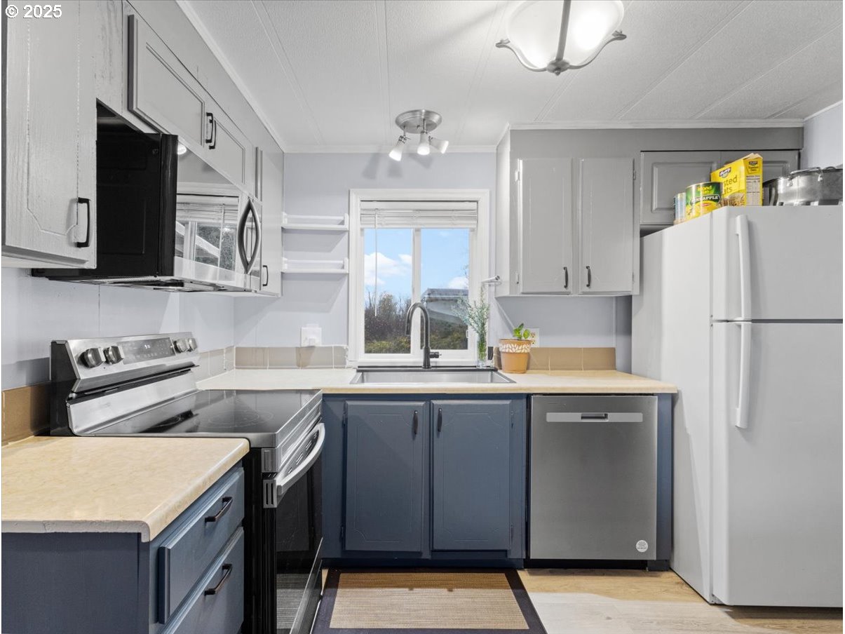 6610 Northwest Whitney Road, Unit 138 Vancouver, WA 98665 - Photo 9 of 34 a kitchen with stainless steel appliances a stove a sink and a refrigerator