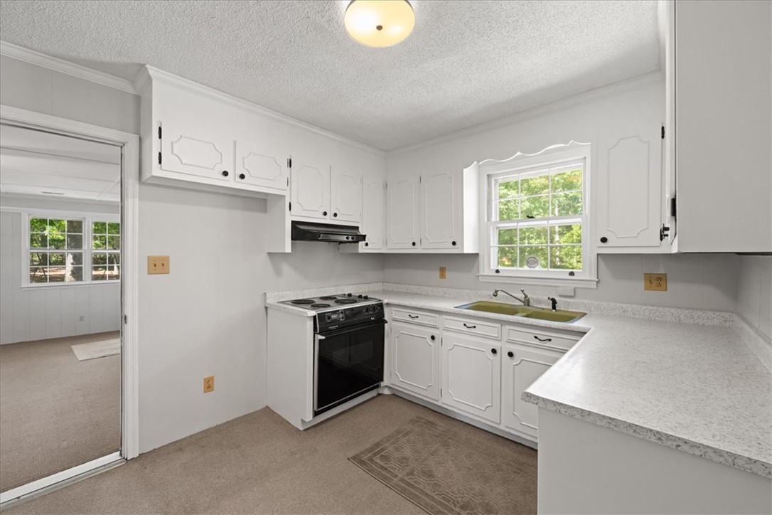 304 Shaw Road Honea Path, SC 29654 - Photo 4 of 39 This bright kitchen features ample cabinetry and a window overlooking lush greenery.
