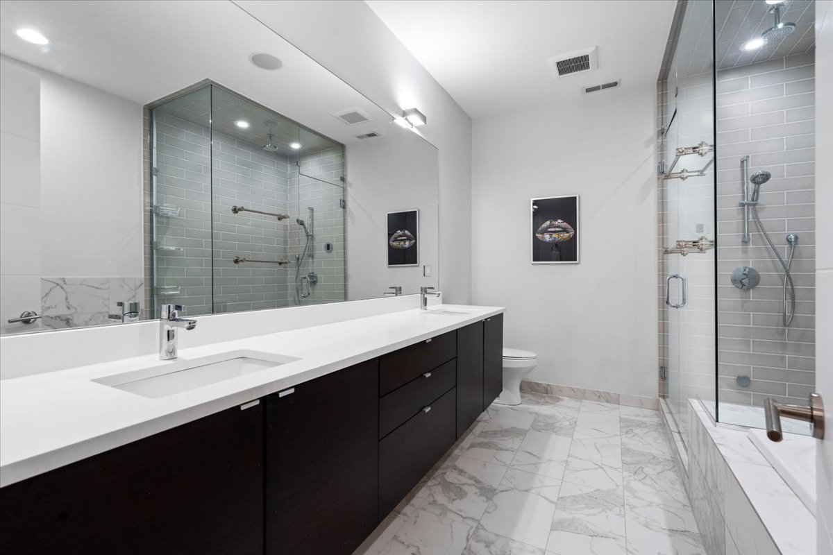 1515 North Mohawk Street, Unit 1 Chicago, IL 60610 - Photo 18 of 34 a bathroom with a double vanity sink mirror and shower