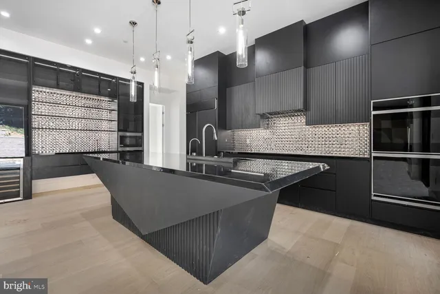 a kitchen with granite countertop a refrigerator a sink and wooden cabinets