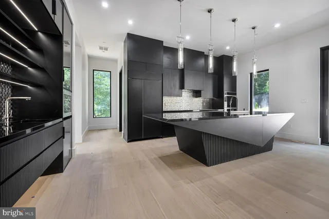 a large kitchen with stainless steel appliances kitchen island granite countertop a large counter top and a stove top oven