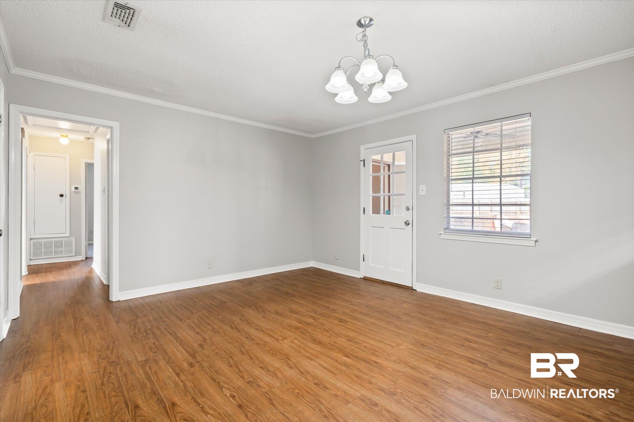 6848 Sandra Drive Theodore, AL 36582 - Photo 19 of 21 Unfurnished room with hardwood / wood-style flooring, ornamental molding, and a chandelier