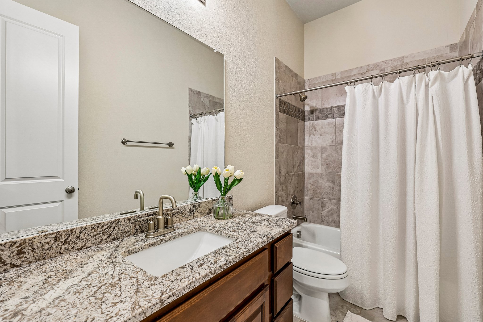 1705 Parten Rnch Parkway Austin, TX 78737 - Photo 13 of 39 A well-appointed bathroom features a granite-topped vanity and a tiled shower-tub combination.